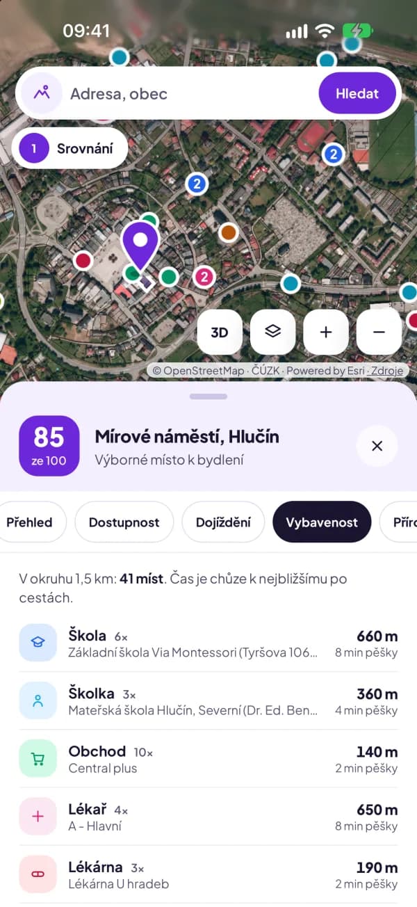 Mobilní aplikace Nadhled na iPhonu. V letecké mapě Hlučína jsou barevné body vybavenosti, pod ní karta místa se skóre 85 a otevřená záložka Vybavenost se seznamem škol, školek, obchodů a lékařů včetně vzdálenosti pěšky.